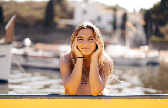 Positive woman chilling on yacht in port