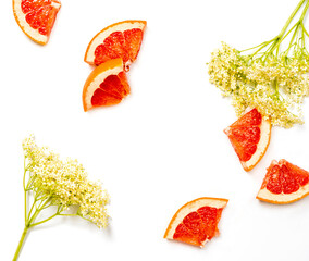 Pieces of grapefruit and elderflower on a white background - 566643366