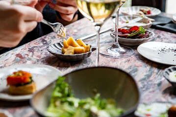 hand take cheese cube on table in restaurant 