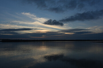 sunset under the clouds by the sea
