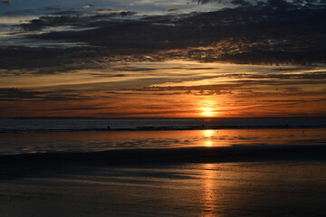 sunset under the clouds by the sea