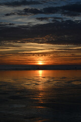 sunset under the clouds by the sea