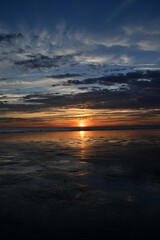 sunset under the clouds by the sea