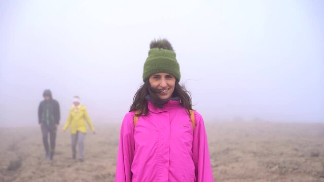 Hiking woman ascending to Roque Nublo duroing a misty morning in Gran Canary Island, Spain.
