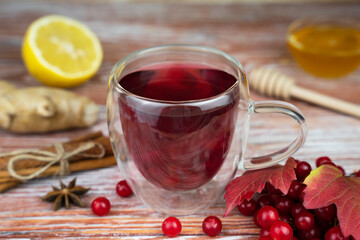 Healthy tea from from viburnum berries with lemon, honey and ginger. Close-up. Selective focus.