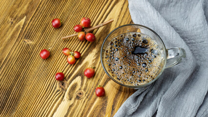 Black coffee in a cup and coffee bean on a wooden table.