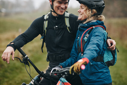 Young couple smiling before a misty morning mountain bike ride
