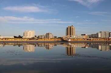 Skyline von Cuxhaven spiegelt sich in der Nordsee bei beginnender Ebbe im Sommer am Abend 