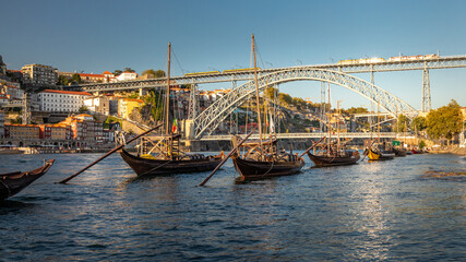 Fototapeta na wymiar Bateaux de transport du vin de Porto devant le pont Dom Luis