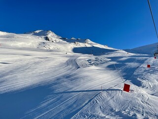 empty slopes in the sun perfectly groomed and waiting for the first skiers