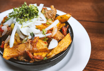 Beef stew with potatoes, carrots and herbs on black background with copy