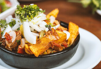 Beef stew with potatoes, carrots and herbs on black background with copy