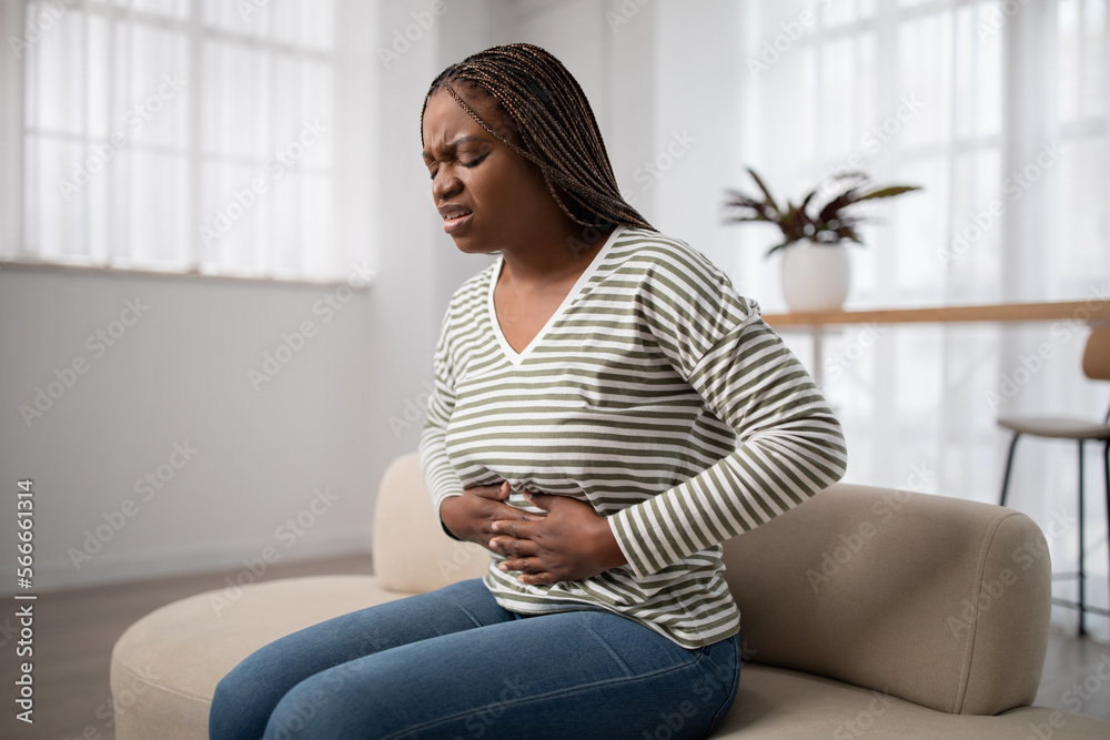 Wall mural Sad black woman wearing casual clothes suffering from menstrual pain