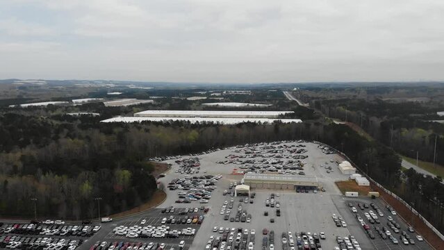 Cars at the Copart junkyard. Aerial view, drone flying over damaged cars in the dealer's parking lot. Selling and sending cars