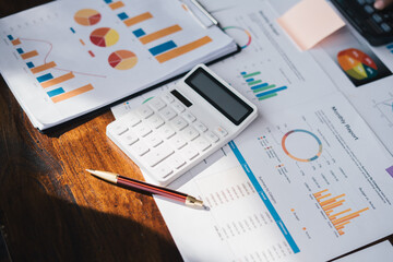 Close up view of company office working table with graphs and calculator.