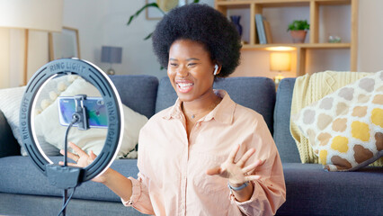 Beauty influencer filming a makeup tutorial at home. Young female blogger live streaming a...