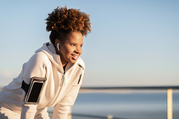 Portrait Of Tired Black Female Jogger Taking Breath While Jogging Outdoors