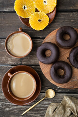 Delicious homemade gluten-free dark chocolate donuts. Sweet breakfast with homemade donuts, coffee with almond milk and fresh fruit