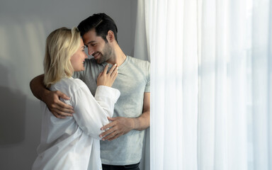 Beautiful young couple warmly embrace in the bedroom.