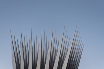 Close up of steel needles or pins against a clear blue sky