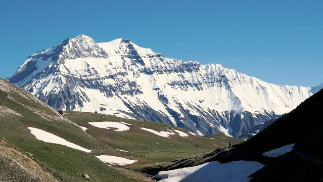 Sommet enneig&eacute; avec plateau herbeux et randonneuse en avant plan - Grande Casse, Parc National de la Vanoise