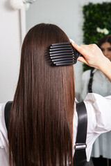 Fototapeta premium A straight healthy brunette hair that has undergone the hair straightening procedure. straight, shiny and healthy brunette hair