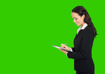 Happy smiling young beautiful business woman with clipboard writing. Green chroma key background.