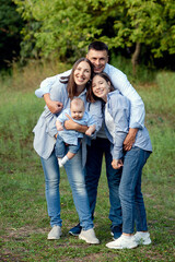 friendly family kid dream concept. lifestyle family walking in the park on the grass at sunset.