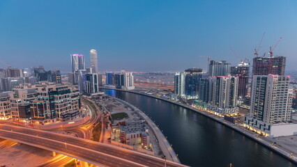 Skyscrapers at the Business Bay aerial day to night in Dubai, United Arab Emirates