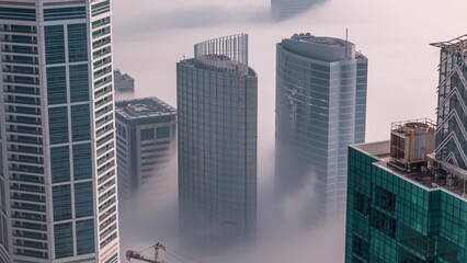 Fototapeta na wymiar Rare early morning winter fog above the Dubai Marina skyline and skyscrapers rooftops aerial .