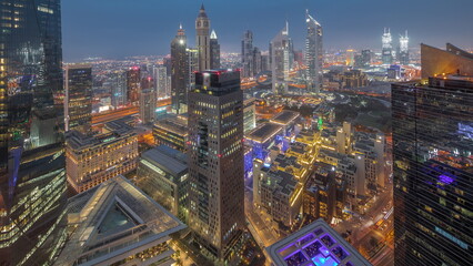 Fototapeta na wymiar Panorama of futuristic skyscrapers after sunset in financial district business center in Dubai day to night