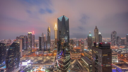 Obraz premium Panorama of futuristic skyscrapers after sunset in financial district business center in Dubai day to night