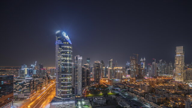 Panorama showing Dubai's business bay towers aerial night . Rooftop view of some skyscrapers