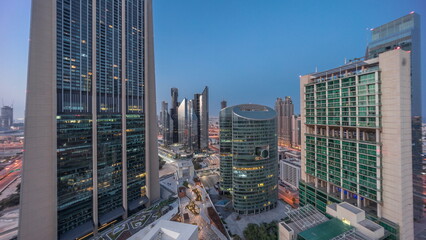 Dubai international financial center skyscrapers aerial night to day .