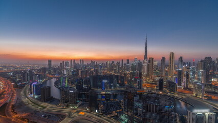Skyline with modern architecture of Dubai business bay towers day to night . Aerial view