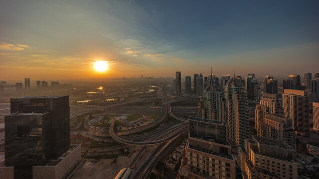 Sunrise over Dubai marina and JLT skyscrapers along Sheikh Zayed Road aerial . © neiezhmakov