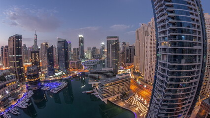Aerial view to Dubai marina skyscrapers around canal with floating boats night to day