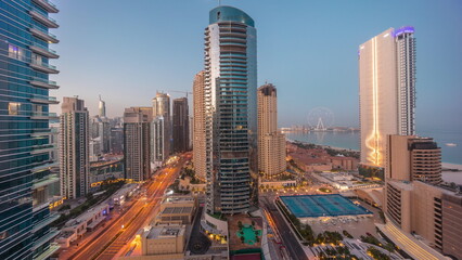 Panoramic view of the Dubai Marina and JBR area and the famous Ferris Wheel aerial night to day