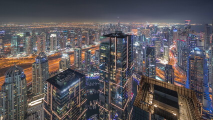 Fototapeta na wymiar Dubai Marina and JLT district with traffic on highway between skyscrapers aerial night .