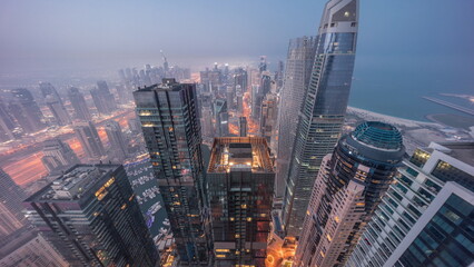Obraz premium Skyline panoramic view of Dubai Marina showing canal surrounded by skyscrapers along shoreline night to day . DUBAI, UAE