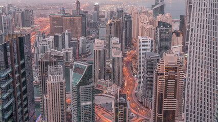 Skyline view of Dubai Marina showing canal surrounded by skyscrapers along shoreline night to day . DUBAI, UAE