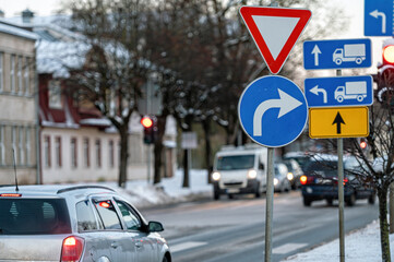 Cars moving on the road in city in winter. View to the traffic with signs, trafficlights and cars