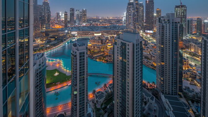 Dubai downtown with fountains and modern futuristic architecture aerial night to day