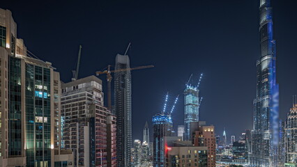 Fototapeta na wymiar Panorama showing aerial cityscape night with illuminated architecture of Dubai downtown.