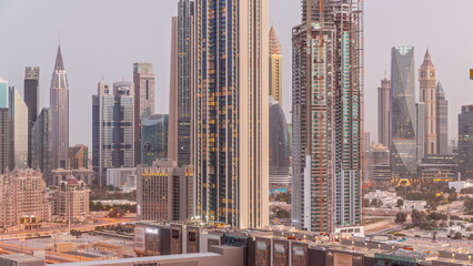 Panorama of the tall buildings around Sheikh Zayed Road and DIFC district aerial night to day in Dubai