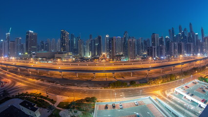 Fototapeta na wymiar Panoraama of Dubai Marina skyscrapers and Sheikh Zayed road with metro railway aerial night to day , United Arab Emirates