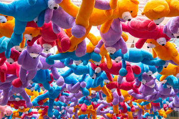 Colorful teddy bears are hanging in the air.