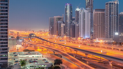 Fototapeta na wymiar Dubai Marina skyscrapers and Sheikh Zayed road with metro railway aerial night to day , United Arab Emirates