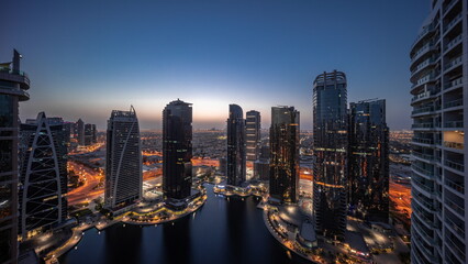 Tall residential buildings at JLT aerial night to day , part of the Dubai multi commodities centre mixed-use district.