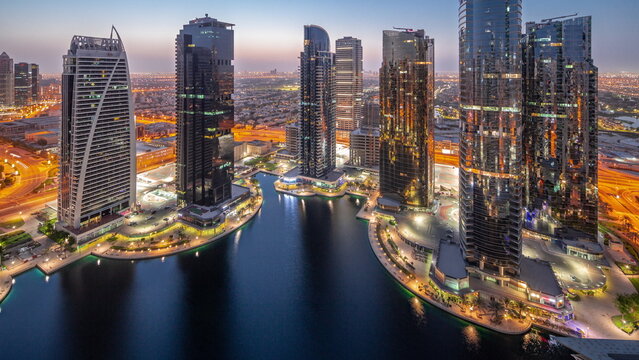Tall residential buildings at JLT aerial night to day , part of the Dubai multi commodities centre mixed-use district.